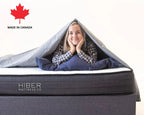 Girl laying on Hiber Mattress with duvet draped over with white background.