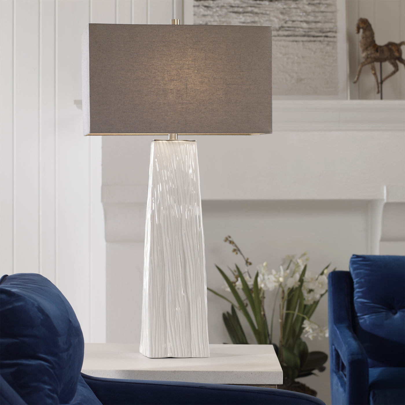 Elegant And Versatile, This Table Lamp Features A Gloss White Ceramic Base Featuring Organic Hand Carved Details And Brush...
