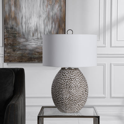 This Ceramic Table Lamp Features A Heavily Pitted Surface, Finished In A Combination Of Brushed Rustic Gray And Crackled G...